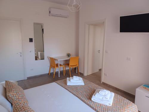 a room with a bed and a table with chairs at House Salento Central Rooms in Torre San Giovanni Ugento
