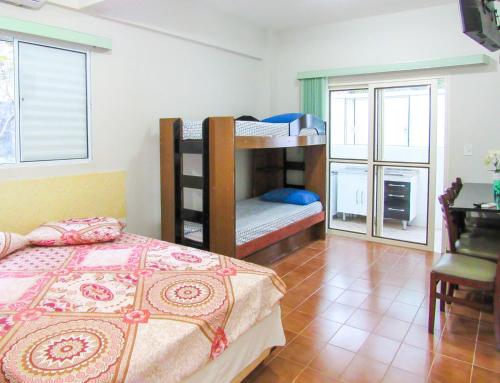 a bedroom with bunk beds and a desk and a bed at Apto c Wi-Fi e lazer na Praia de Tabatinga SP in Caraguatatuba