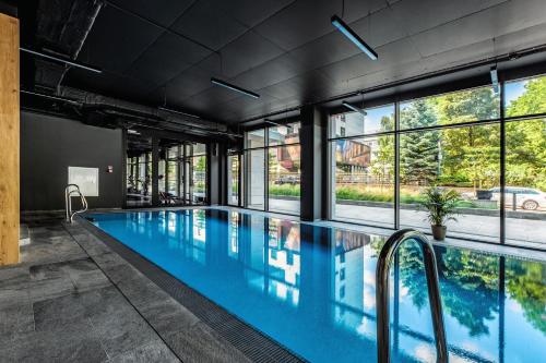 a swimming pool with blue water in a building with windows at AURUM PREMIUM SPA UNIA RESIDENCE in Lublin