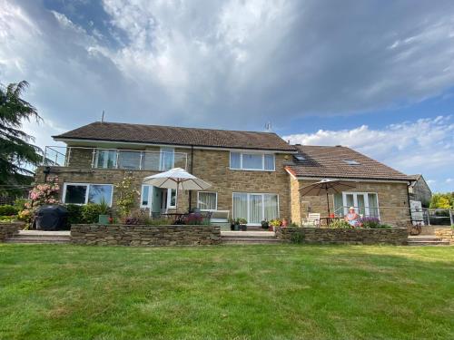 a brick house with an umbrella in a yard at Millbrook in Penistone