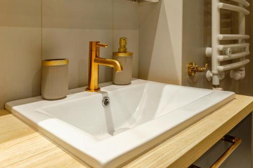 a white sink with a gold faucet in a bathroom at AURUM PREMIUM SPA UNIA RESIDENCE in Lublin