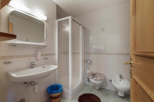 a white bathroom with a sink and a toilet at Garni Ziernheld in Malles Venosta