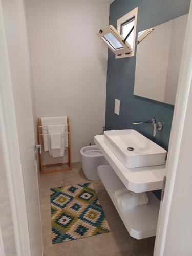 a bathroom with a sink and a toilet and a mirror at House Salento Central Rooms in Torre San Giovanni Ugento