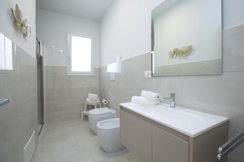 ein weißes Badezimmer mit Waschbecken und Toilette in der Unterkunft Residence BLANCO GARDEN 1 a 100 mt dalla spiaggia di Posto Vecchio Marina di Pescoluse in Marina di Pescoluse
