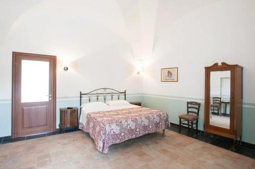 a bedroom with a bed and a mirror and a chair at Masseria Agriturismo Moschella in Lavello