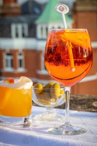 a glass of orange juice and a drink on a table at San Domenico House in London