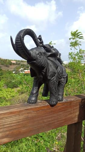 a statue of an elephant standing on a wooden fence at Kawaida - Hébergement insolite - Makazi in Sainte-Luce