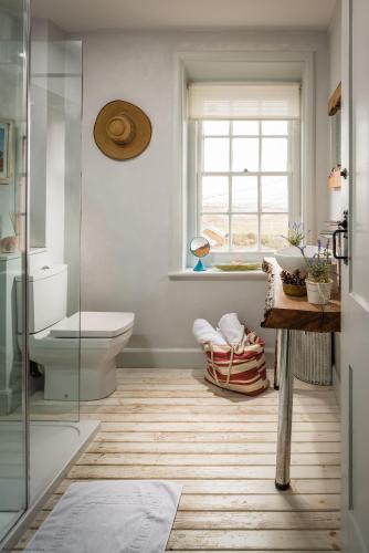 a bathroom with a toilet and a glass shower at Coastguards Lookout in Camber