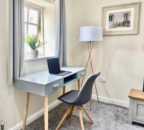 a desk with a laptop and a chair in a room at 4c Gaia Lane in Lichfield
