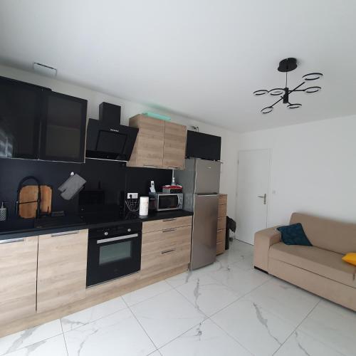 Il comprend un salon avec une cuisine et un canapé. dans l'établissement Appartement EVR!CA - 1 place parking gratuit, au Perrier