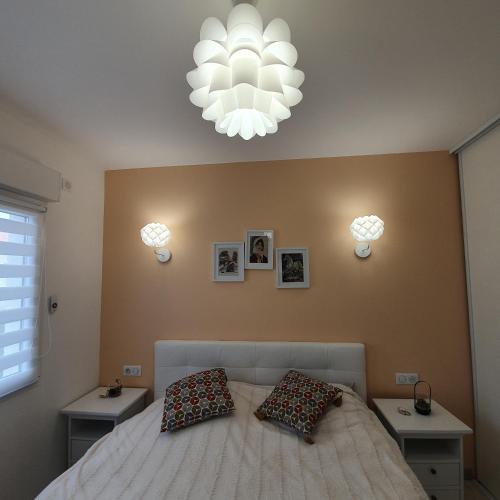 une chambre avec un lit avec deux oreillers dessus dans l'établissement Appartement EVR!CA - 1 place parking gratuit, au Perrier