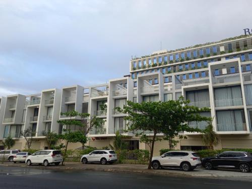 a large building with cars parked in front of it at Tuy Hòa Beach Hotel - Căn hộ du lịch in Tuy Hoa