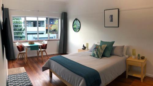 1 dormitorio con cama, mesa y ventana en Studio 5 Milford House, en Ciudad del Cabo