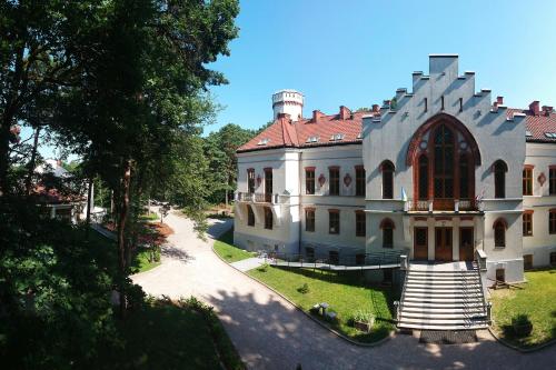 un grand bâtiment avec une tour en haut dans l'établissement Dobry Zakątek Dom Rekolekcyjny, à Konstancin-Jeziorna
