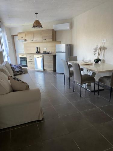 een keuken en een woonkamer met een tafel en stoelen bij Charmant logement avec piscine in Le Cannet-des-Maures