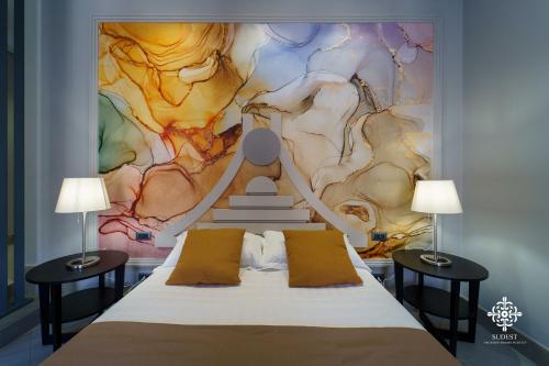 a bedroom with a bed with two lamps at Matteotti Luxury Residence in Siracusa