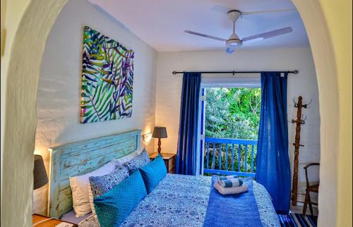 een slaapkamer met een blauw bed en een raam bij Mediterranean beach villa - FAMILIES ONLY in Ballito