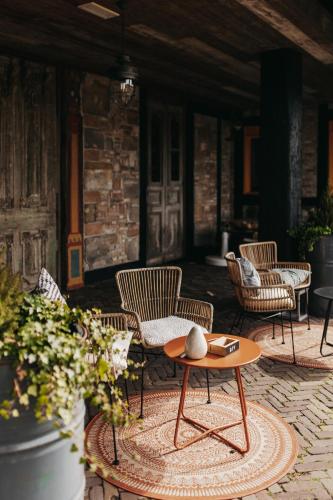 a patio with chairs and a coffee table on a rug at Hotel Inn Salland in Raalte