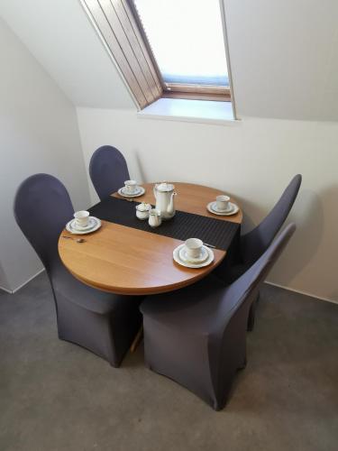 a table and chairs with cups and saucers on it at Fewos Familie Krysik in Lühmannsdorf