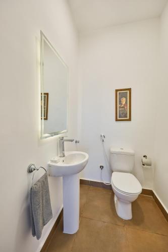 a white bathroom with a toilet and a sink at Le Royal Marina Hotel in El Alamein