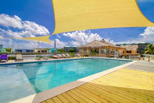 a pool at a resort with a large yellow umbrella at Suite F201 @ Mara Laguna in San Pedro
