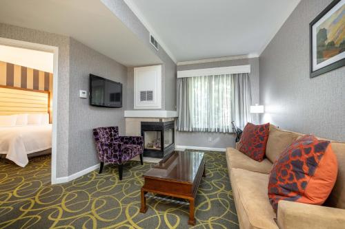 a living room with a couch and a room with a bed at Best Western Plus Dixon Davis in Dixon