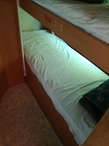 a bottom bunk of a bunk bed with white sheets at Zielony Port numer 3 in Władysławowo