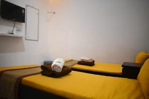 a hotel room with two beds and a tv at House of A Syariah Sukarame in Tanjungkarang