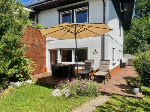a patio with a table and a yellow umbrella at Casparidyll in Sigmaringen