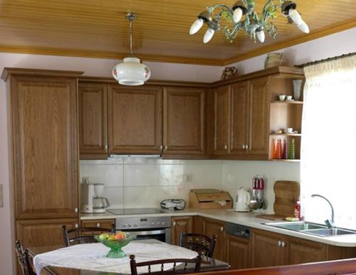 a kitchen with wooden cabinets and a table with chairs at Villa Ermis in Lákka