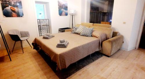 uma sala de estar com uma cama e um sofá em Casa Giulia em Luino
