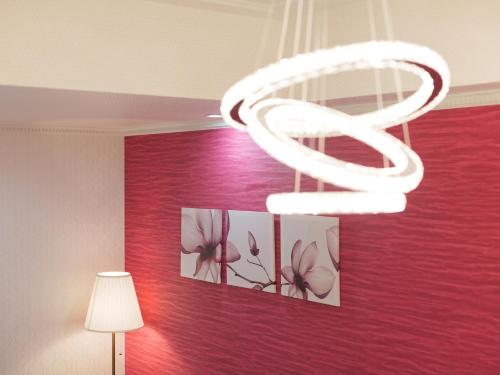 a white chandelier in a room with a red wall at Fun3 -Adult Only- in Yokohama