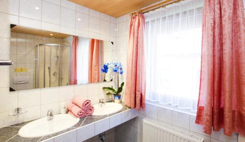 ein Bad mit 2 Waschbecken und einem Fenster in der Unterkunft Haus Berthold in Sölden