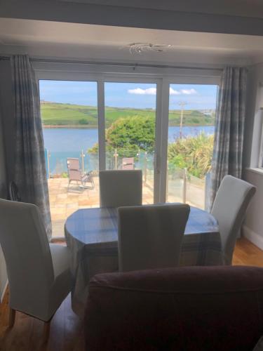 a dining room with a table and chairs and a large window at Centrally located coastal townhouse Belmullet in Belmullet