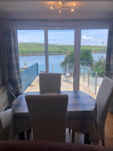 a dining room table with chairs and a view of a lake at Centrally located coastal townhouse Belmullet in Belmullet