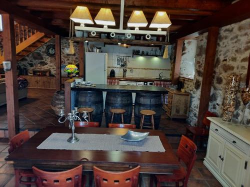 a kitchen with a wooden table and a bar at Casa Rural Alto Santiago in Santiago del Collado