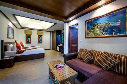 ein Wohnzimmer mit einem Bett und einem Sofa in der Unterkunft Pai Tan Villas - SHA Extra Plus in Strand Bang Tao