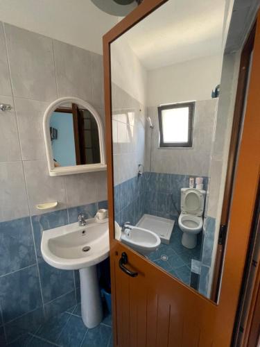a bathroom with a sink and a toilet and a mirror at Festim hotel in Durrës