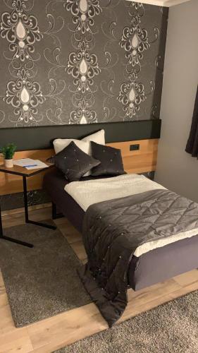 a bedroom with a bed and a table and a wall at Pension auf dem Land in Kevelaer
