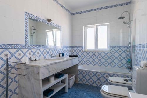 a bathroom with a sink and a toilet and a mirror at Villa Ferragudo, Piscina e Mesa de Bilhar! in Ferragudo