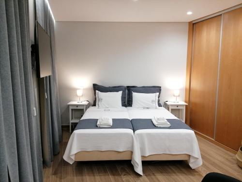een slaapkamer met een groot bed en 2 nachtkastjes bij Apartments Madeira Funchal City in Funchal