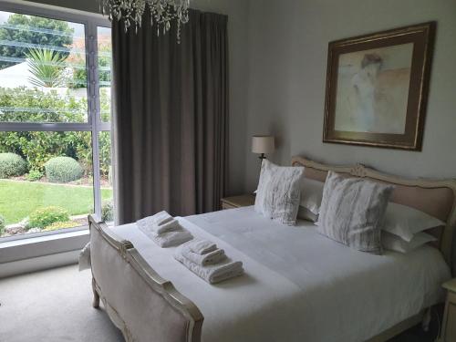 um quarto com uma cama branca e toalhas em Margie's Place em Swellendam