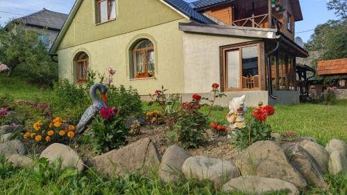 un jardin avec des fleurs en face d'une maison dans l'établissement Zatishok Bilya Richky, à Pilipets