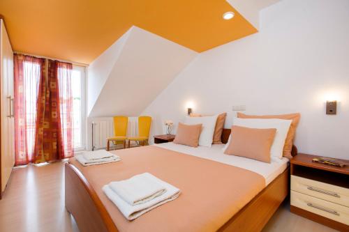sypialnia z dużym łóżkiem i pomarańczowym sufitem w obiekcie Room in Apartment - Cosy and modern family apartment for 4 w mieście Promajna