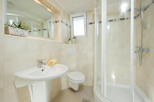 e bagno con servizi igienici, lavandino e doccia. di Room in Apartment - Cosy and modern family apartment for 4 a Promajna