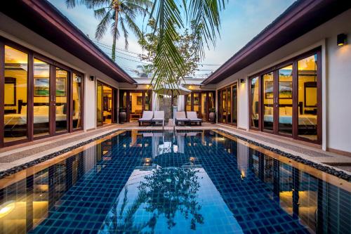 a swimming pool in a villa with a resort at Pai Tan Villas - SHA Extra Plus in Bang Tao Beach