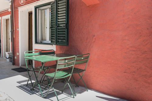 a table and chairs sitting next to a red wall at N255 - Numana, trilocale con aria condizionata in Marcelli