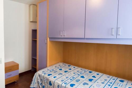 a small bedroom with a bed and white cabinets at N255 - Numana, trilocale con aria condizionata in Marcelli