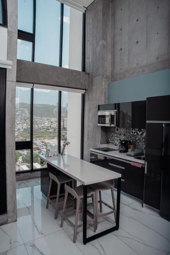 a kitchen with a table and a large window at Luxury Loft Monterrey City Living at Landmark High Rise in Monterrey