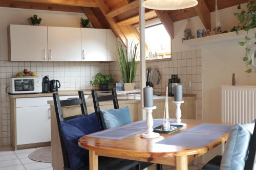 a kitchen and dining room with a wooden table and chairs at Ferienhaus Poseidon in Dorum Neufeld